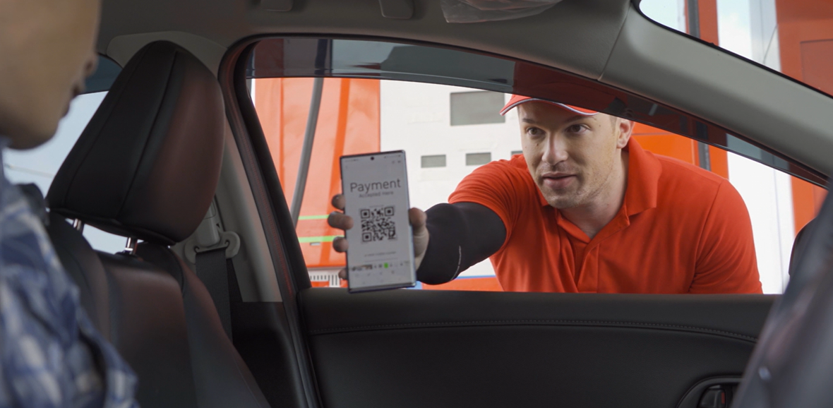 Cliente pagando en bomba de gasolina con celular